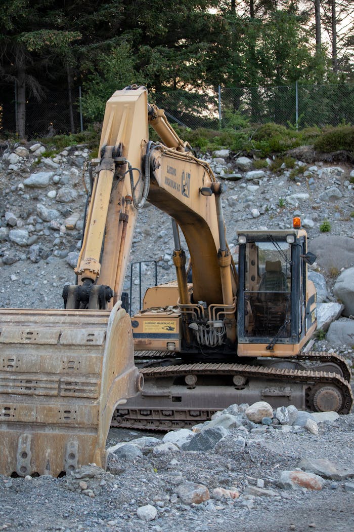 Excavator working in a rocky field in Norway, showcasing heavy machinery operation.